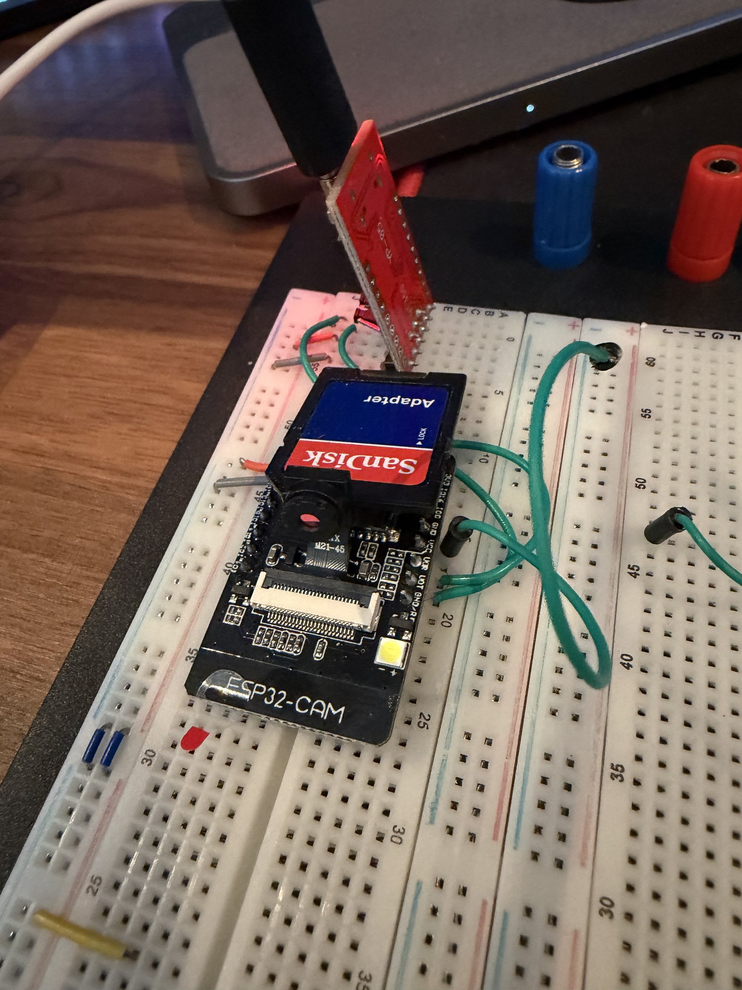 The ESP32-CAM on the breadboard with a SanDisk SD adapter next to it