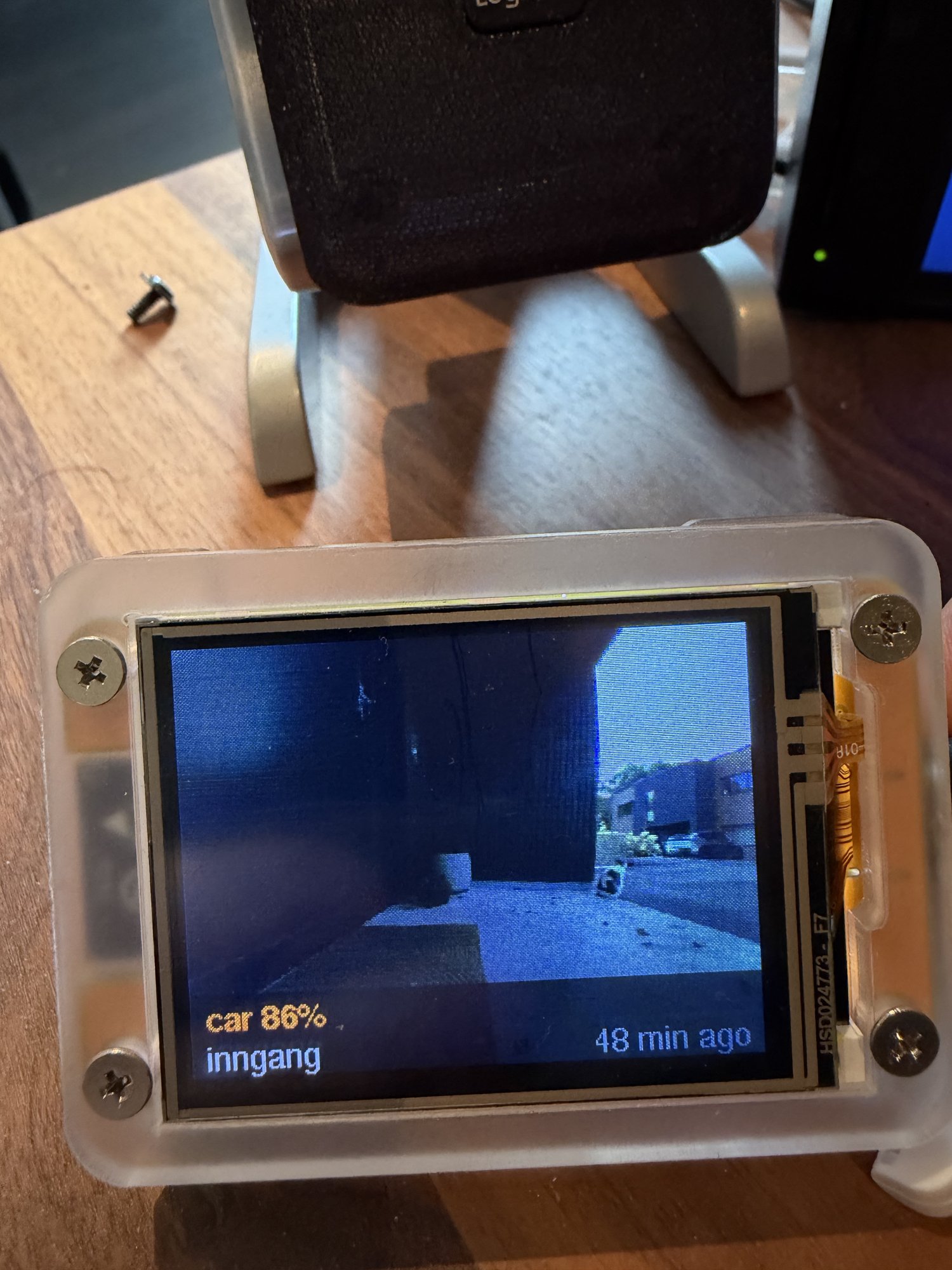 The photo frame showing the entrance camera with car 86% and 48 min ago