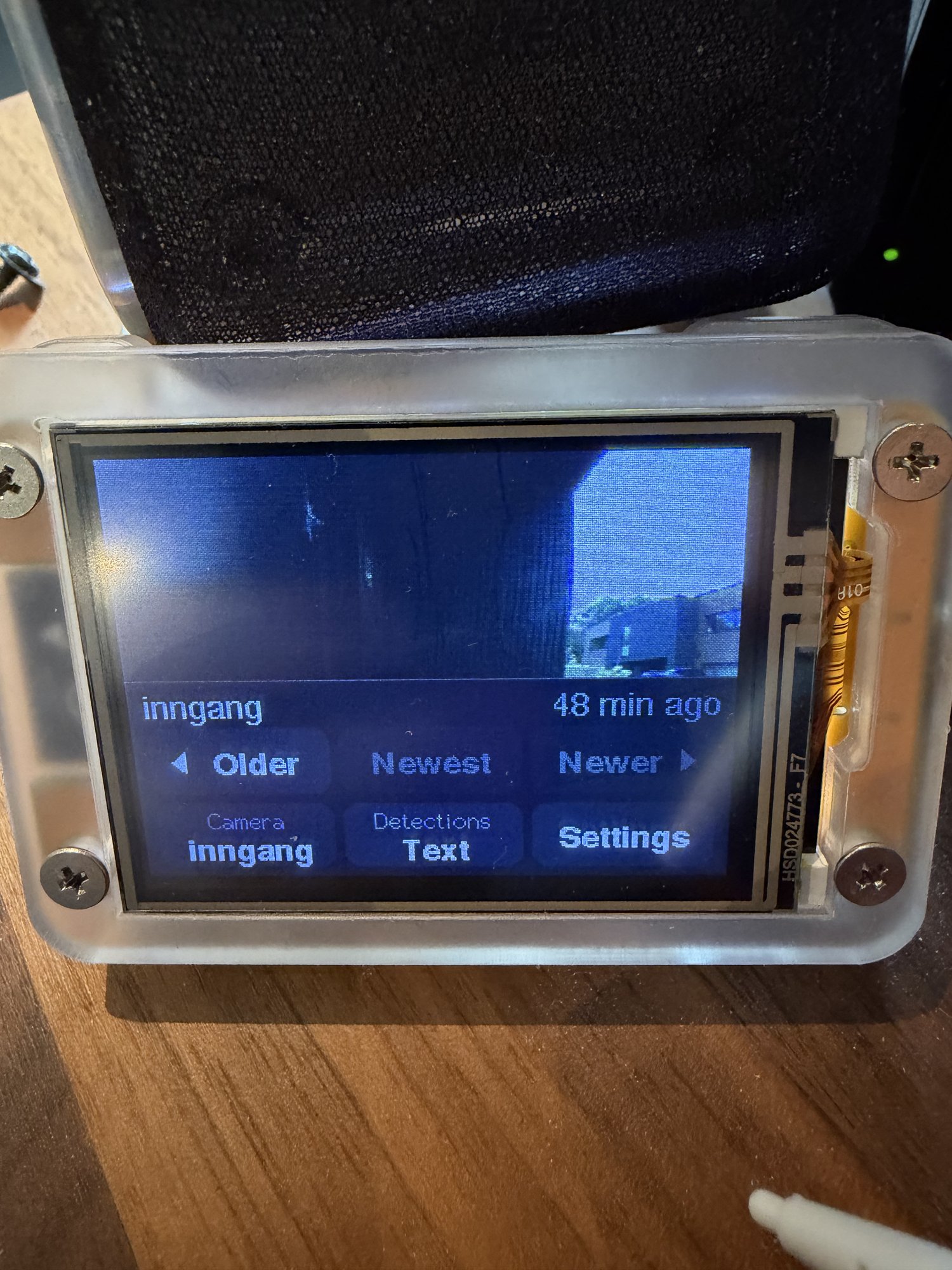 The photo frame with its touch menu open: Older, Newest, Newer, Camera, Detections and Settings